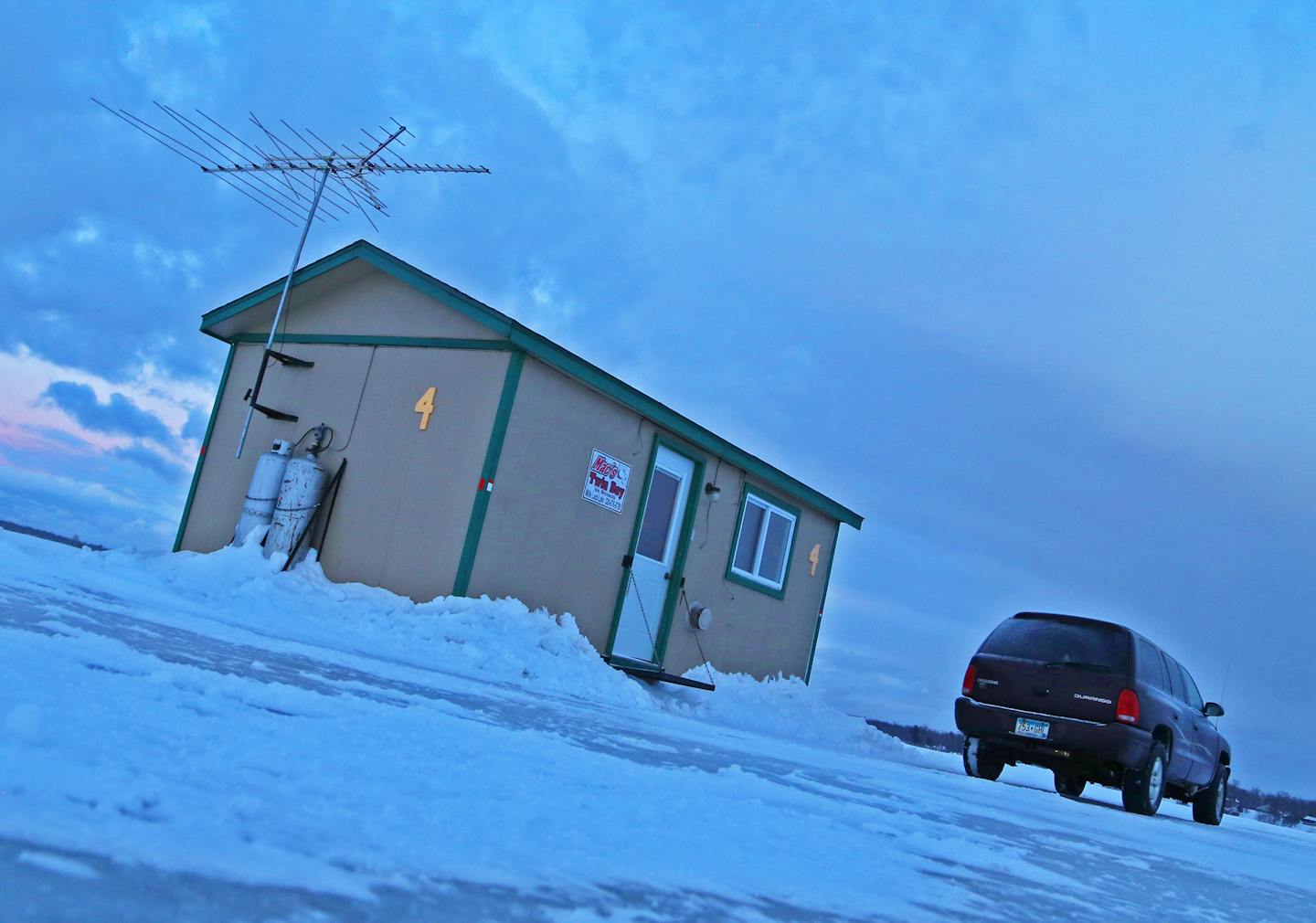 As dusk settles over frozen lake Mille Lacs on a chilly, windy day, the four occupants of a toasty-warm fish house prepare to wind up their afternoon cribbage game.