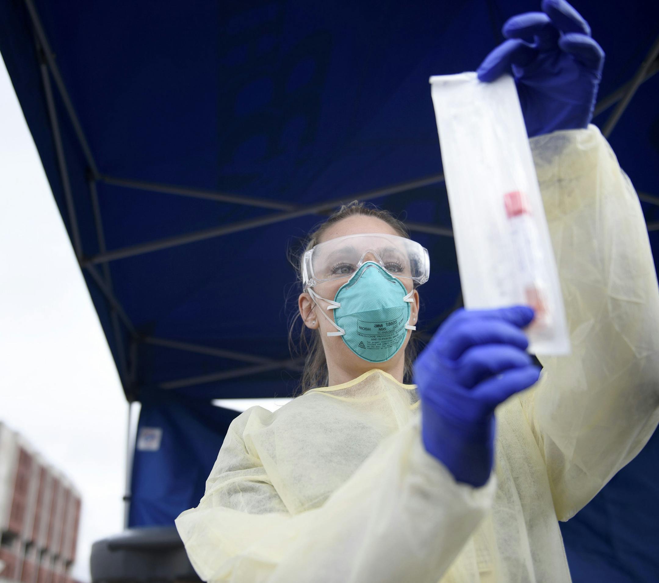 Bristol Hospital Nurse and Emergency Room Operations Manager Meagan DeFazio holds a virus testing kit outside Bristol Hospital where a drive-through COVID19 testing facility has been established. Patients are allowed to enter the area if their doctor has ordered the test. (Mark Mirko/Hartford Courant/TNS) ORG XMIT: 1613890
