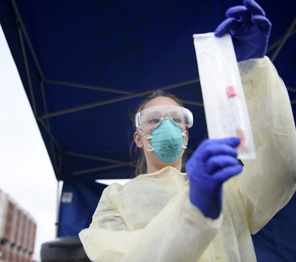 Bristol Hospital Nurse and Emergency Room Operations Manager Meagan DeFazio holds a virus testing kit outside Bristol Hospital where a drive-through C