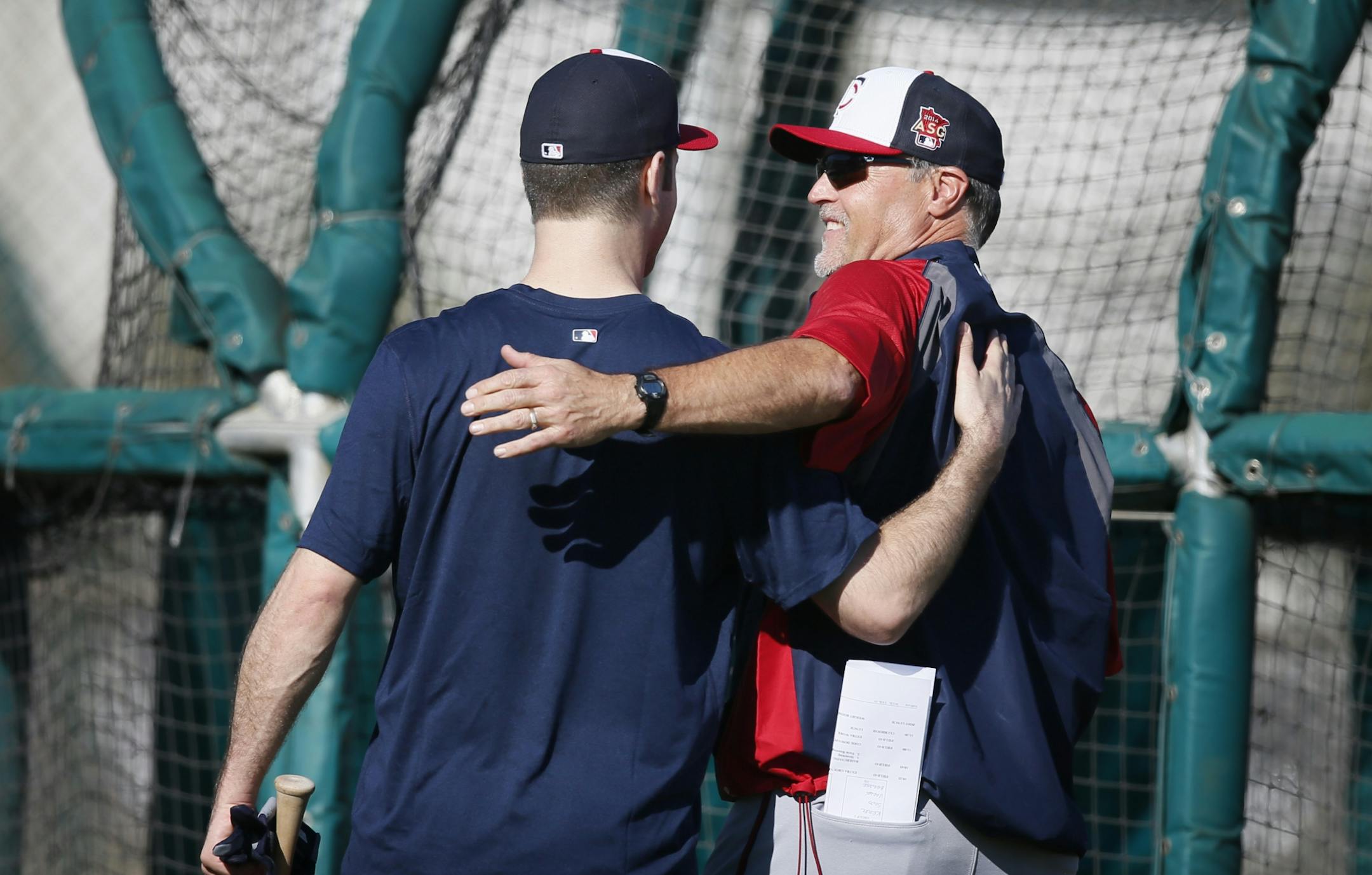 First baseman Joe Mauer left hugged hitting coach Tom Brunansky during spring training practice Tuesday Feb 17. 2014 in Fort Myers, Florida Lee County Sports Complex..