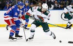 Minnesota Wild's Mats Zuccarello controls the puck in front of New York Rangers' Ryan Strome during the second period Friday night.