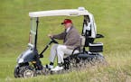 FILE - In this July 31, 2015 file photo, Republican presidential candidate Donald Trump drives his golf buggy during the second day of the Women's Bri