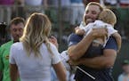 Dustin Johnson, right, greets his fianc&#xc8;&#xed; Paulina Gretzky as he holds their son Tatum Gretzky on the 18th hole during the final round of the