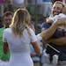 Dustin Johnson, right, greets his fianc&#xc8;&#xed; Paulina Gretzky as he holds their son Tatum Gretzky on the 18th hole during the final round of the