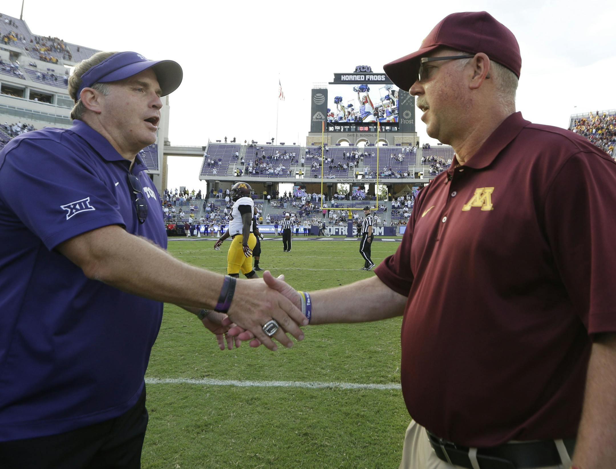 TCU head coach Gary Patterson, left, shakes hands with Minnesota head coach Jerry Kill after an NCAA college football game, Saturday, Sept. 13, 2014, in Fort Worth, Texas. TCU won 30-7. (AP Photo/LM Otero) ORG XMIT: TXMO116
