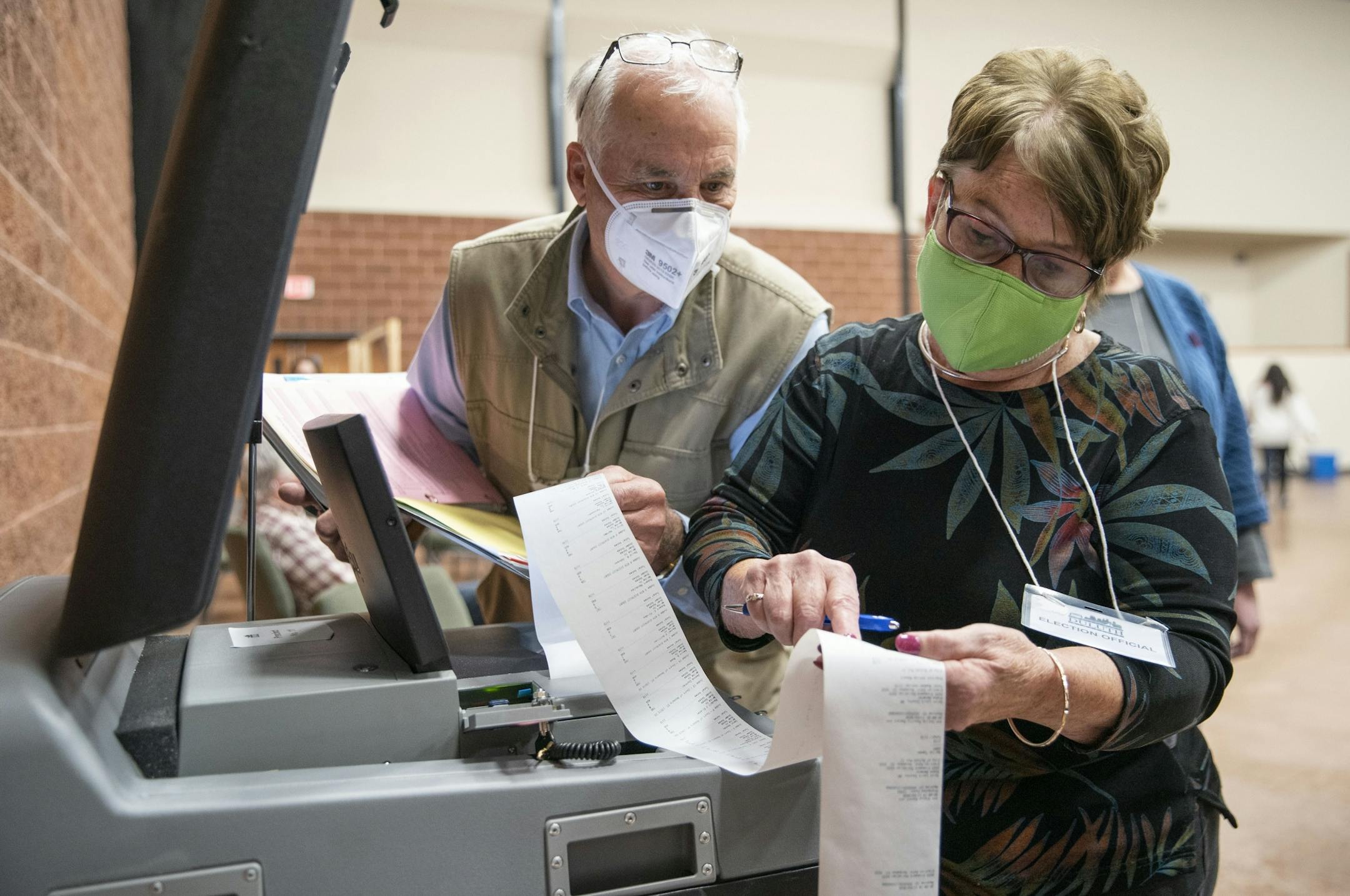(Left) Duluth's 11th precinct co-head polling judges John Keenan and Kathie Trotta read off the in-person ballot counts for the presidential and U.S. Senate races to an Associated Press stringer after the polls closed.