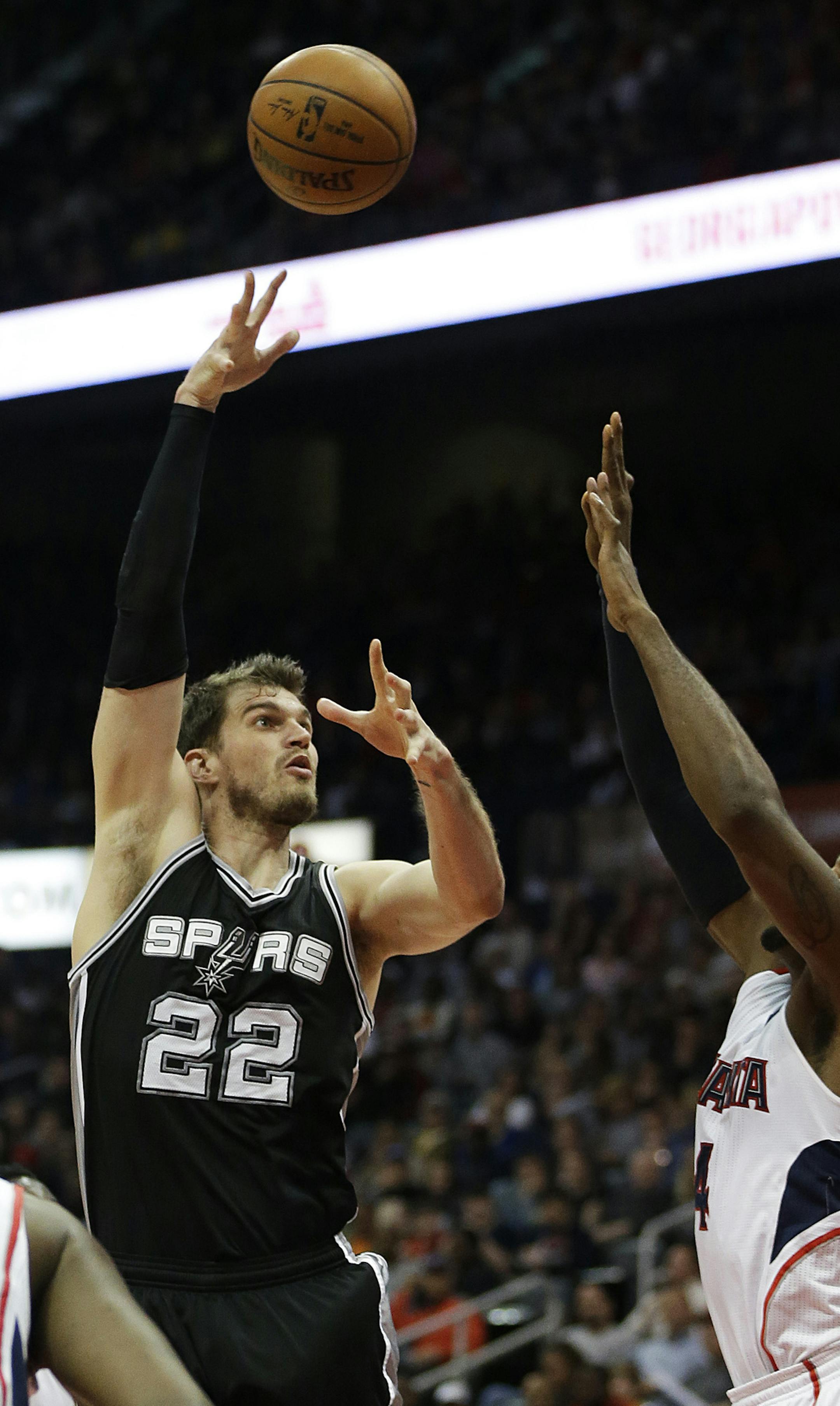 San Antonio Spurs' Tiago Splitter, of Brazil, left, shoots against the defense of Atlanta Hawks' Paul Millsap during the second quarter of an NBA basketball game Sunday, March 22, 2015, in Atlanta. (AP Photo/David Goldman)