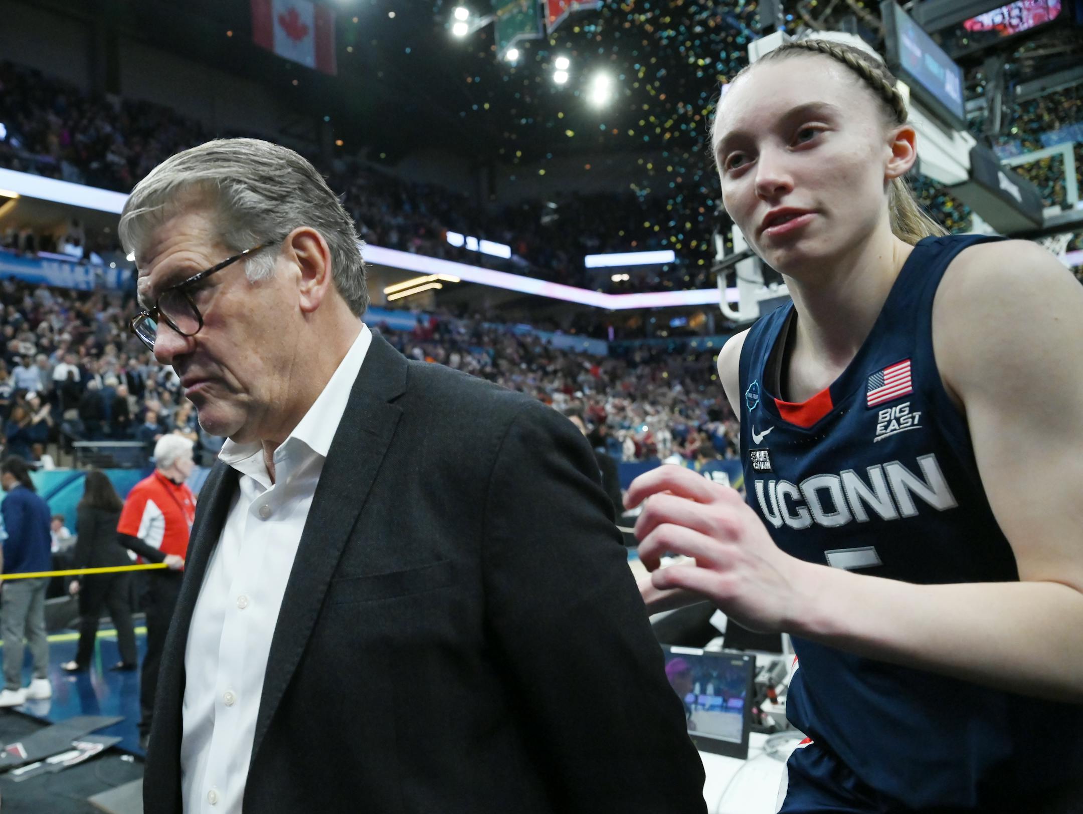 UConn head coach Geno Auriemma and UConn guard Paige Bueckers (5) walk off the court after their loss to South Carolina.