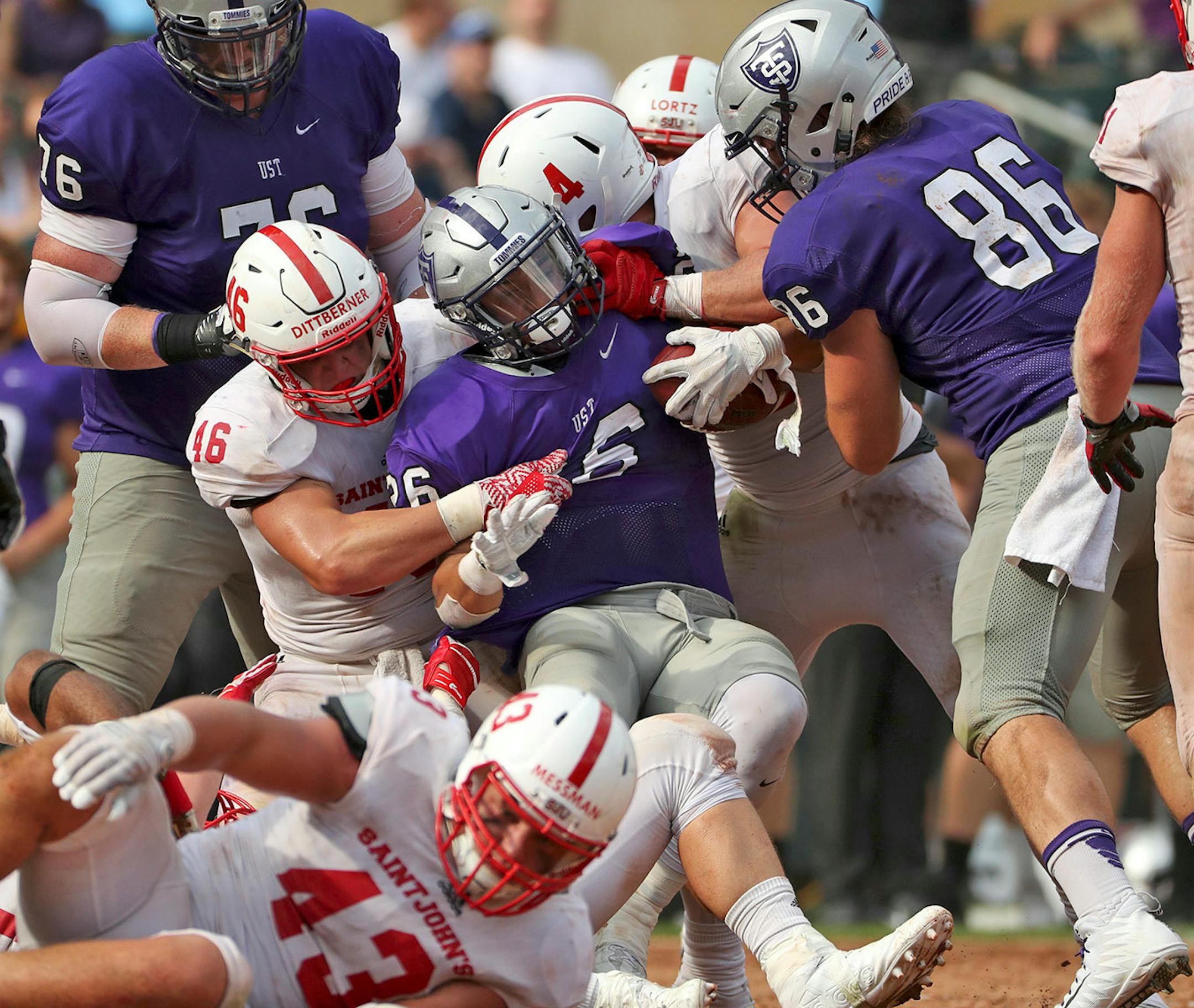 University of St. Thomas running back Josh Parks (26) was pulled down by St. John's University defensive lineman Trevor Dittberner (46) in the second half.