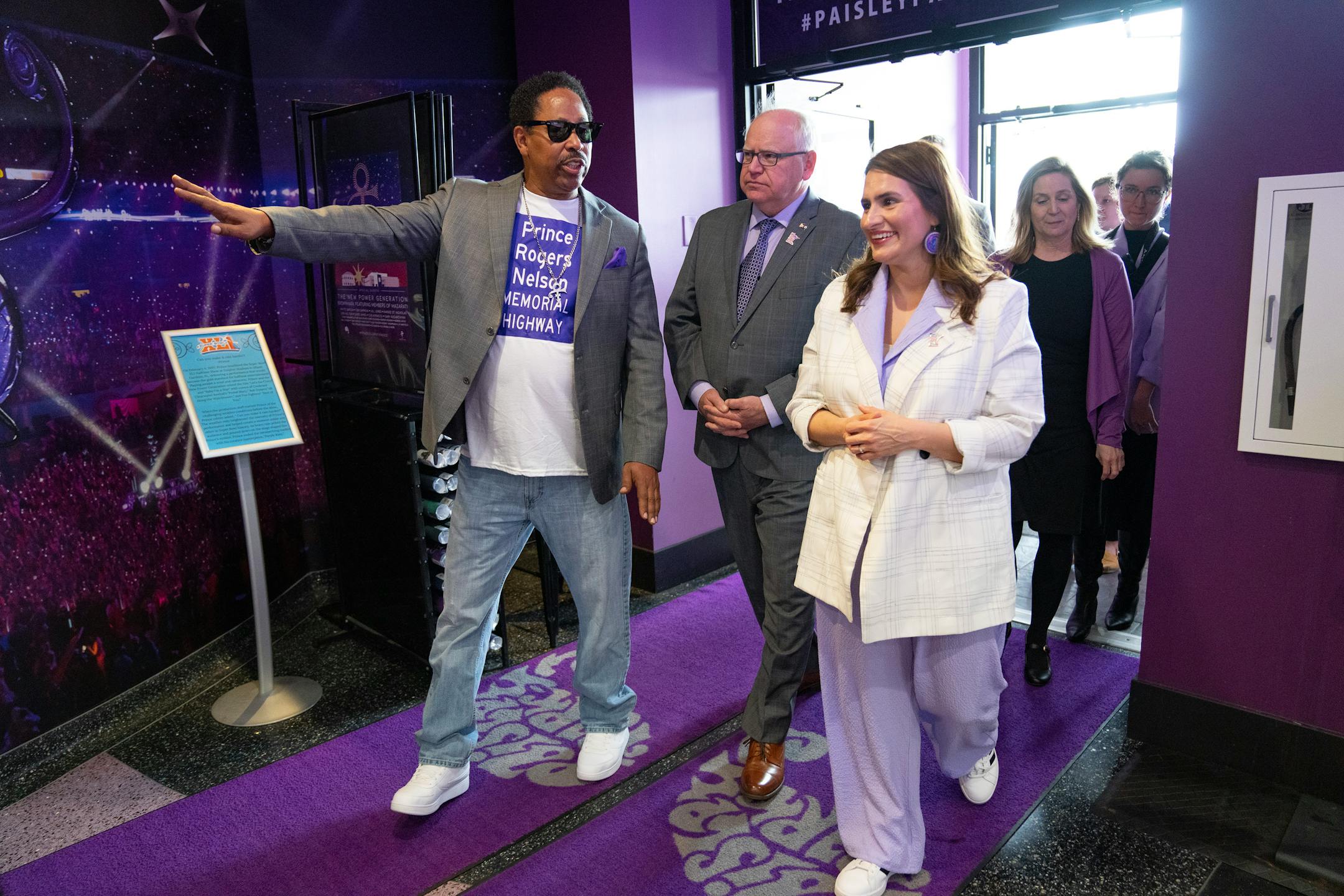 Mark Webster leads Minnesota Governor Tim Walz, Lieutenant Governor Peggy Flanagan and state representative Lucy Rehm, left to right, into Paisley Park together to sign the bill renaming County Road 5 "Prince Rogers Nelson Memorial Highway."