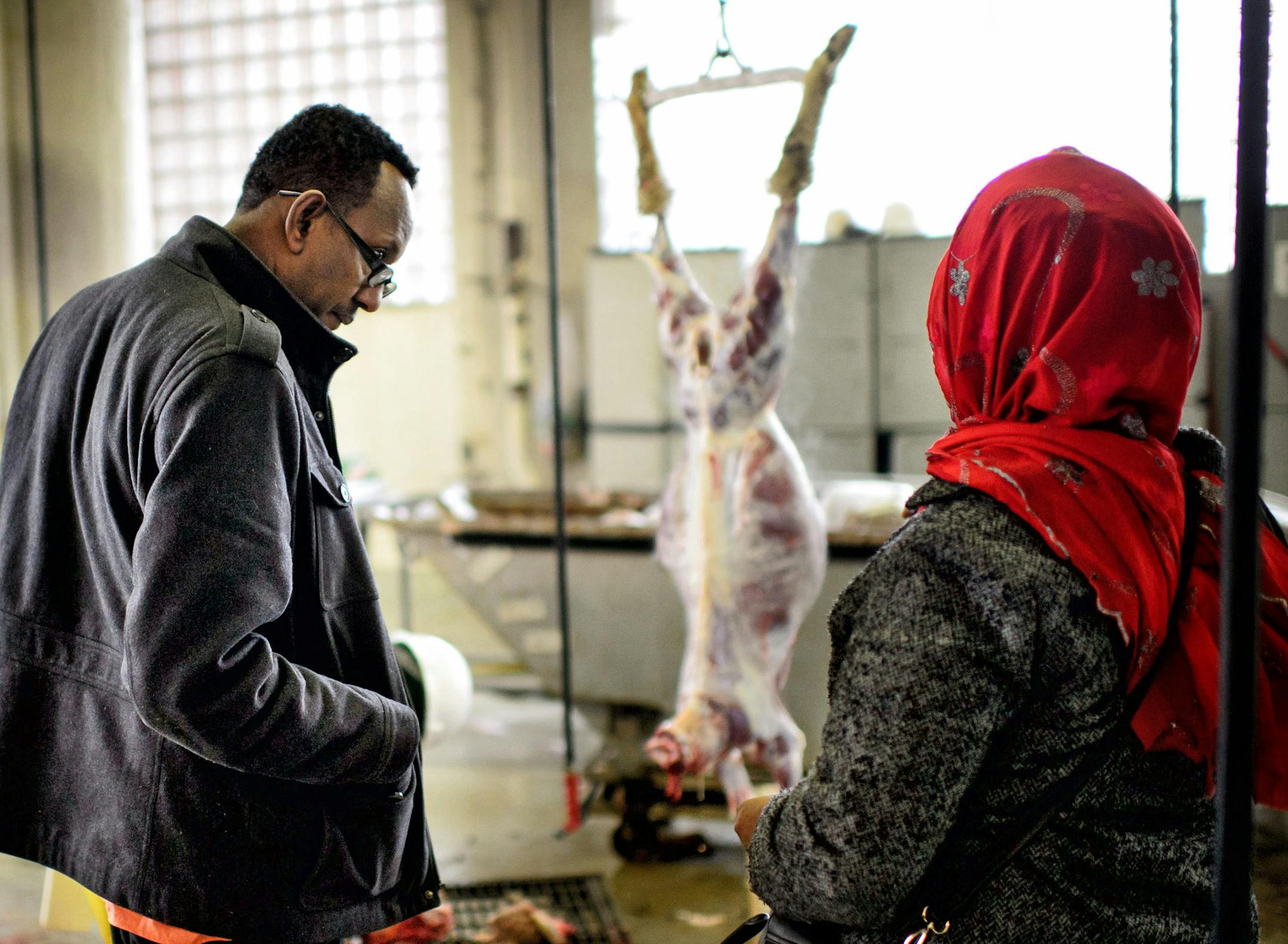 The Somali customers, Ali Hasni, left and his family friend watched as first the sheep then the goat was stunned then bled before butchering.