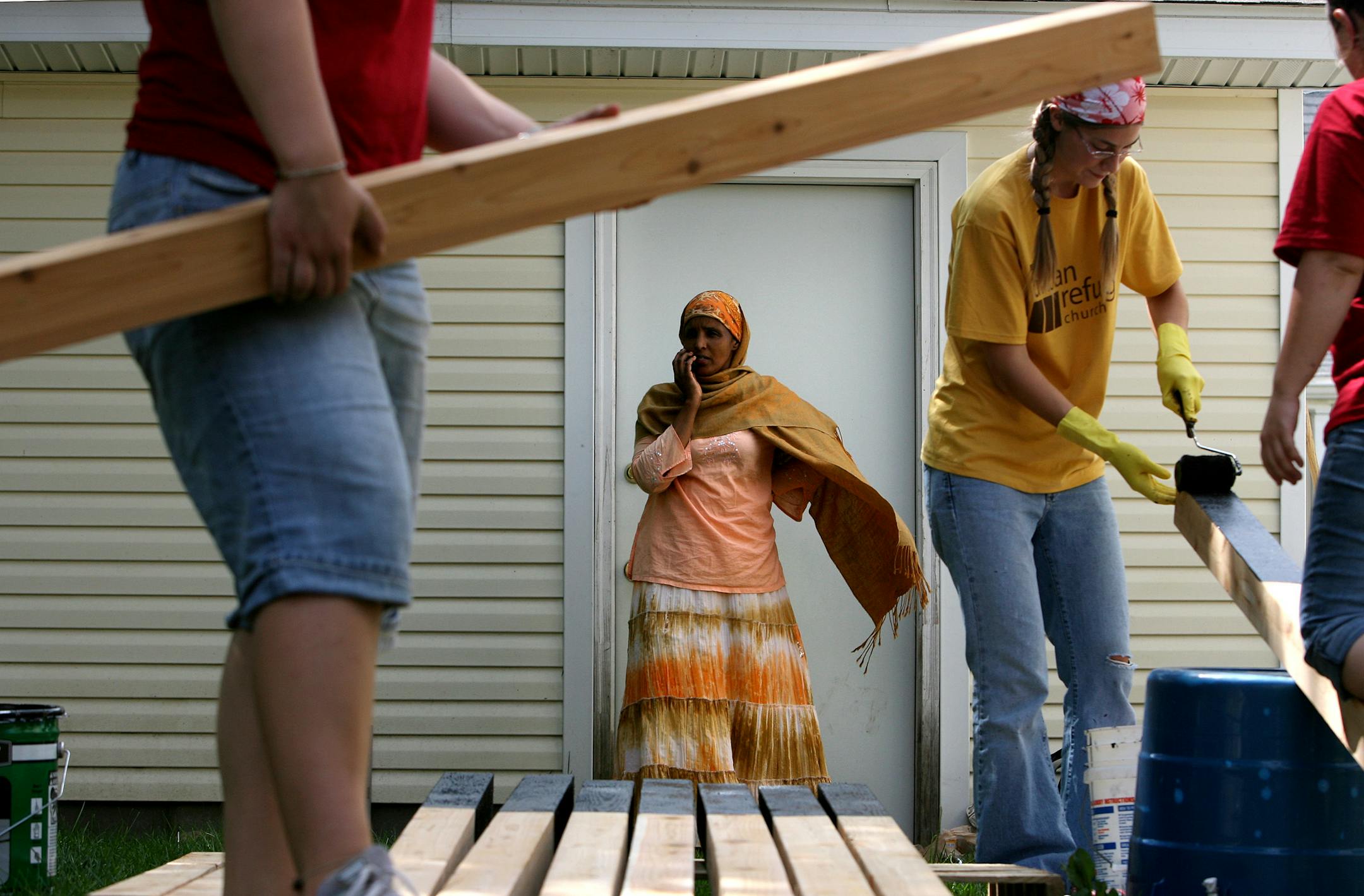 Sadia Noor looked on as Becky Nelson and other volunteers worked on building a fence in Sadia's south Minneapolis backyard.