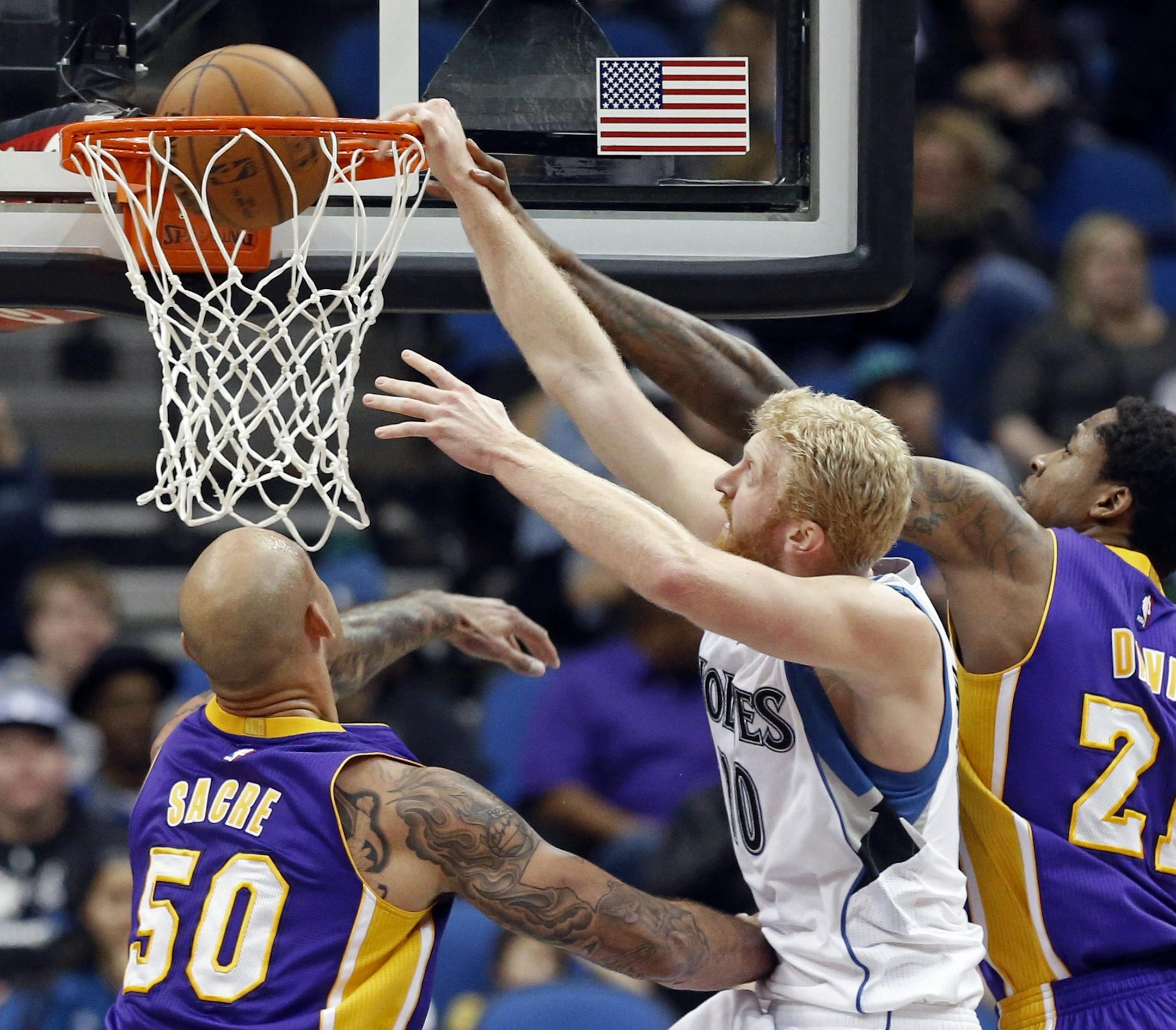 Minnesota Timberwolvesí Chase Budinger dunks despite the defense of Los Angeles Lakersí Ed Davis, right, during the second half of an NBA basketball game, Wednesday, March 25, 2015, in Minneapolis. The Lakers won 101-99 in overtime. (AP Photo/Jim Mone)