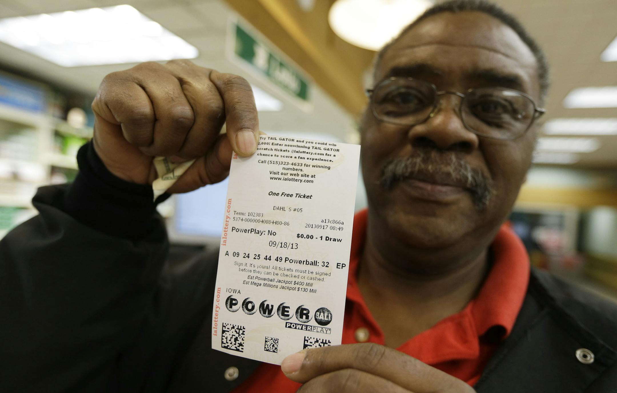 Laric Elbert shows his Powerball ticket, Tuesday, Sept. 17, 2013, in Des Moines, Iowa. The giant Powerball jackpots keep coming, with the latest $400 million prize ranking among the largest ever. But soon, lottery players could see even more huge jackpots as organizers of the Mega Millions lottery move ahead with plans to revamp the game and attract more players. (AP Photo/Charlie Neibergall)