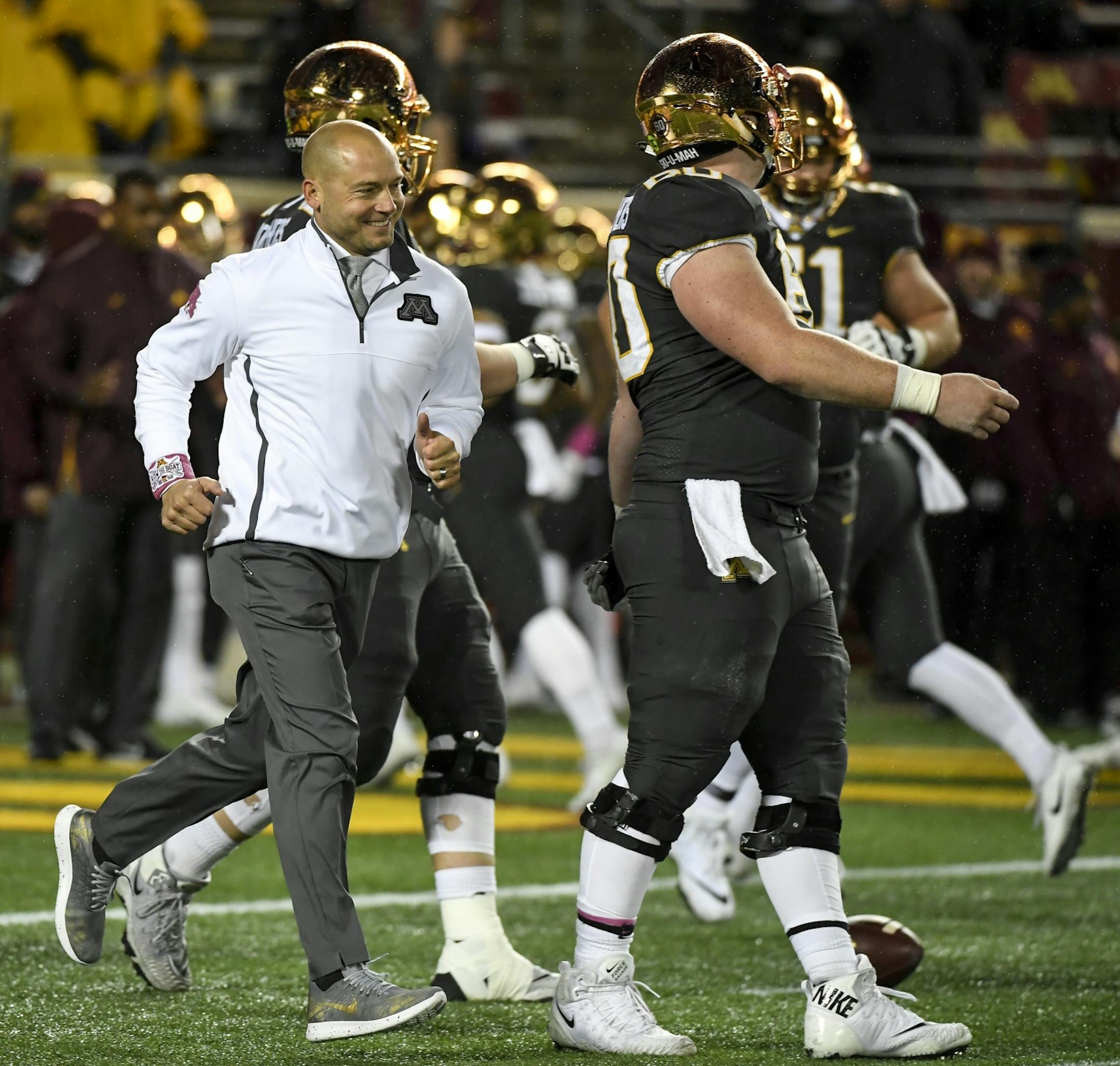 Minnesota Golden Gophers head coach P.J. Fleck ran along with his players during warmups Friday night.