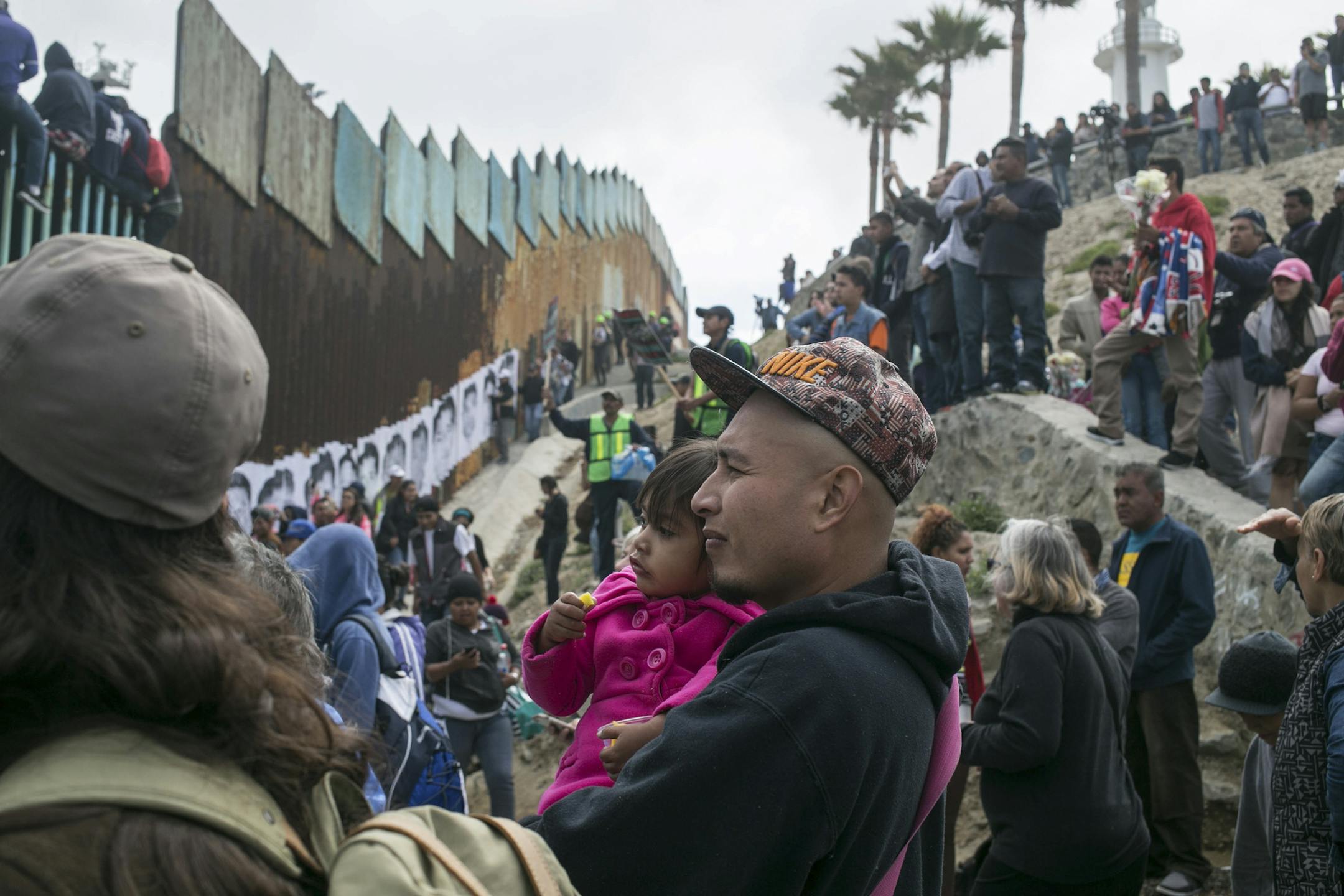 Hundreds of migrants from Central America who traveled as a caravan en masse through Mexico gather with supporters at the border wall with the U.S., where it ends at the Pacific Ocean, in Tijuana, Mexico April 29, 2018. On Friday and Saturday, volunteer immigration lawyers and paralegals met with some of the migrants individually to review their asylum requests to enter the U.S. (Meghan Dhaliwal/The New York Times)