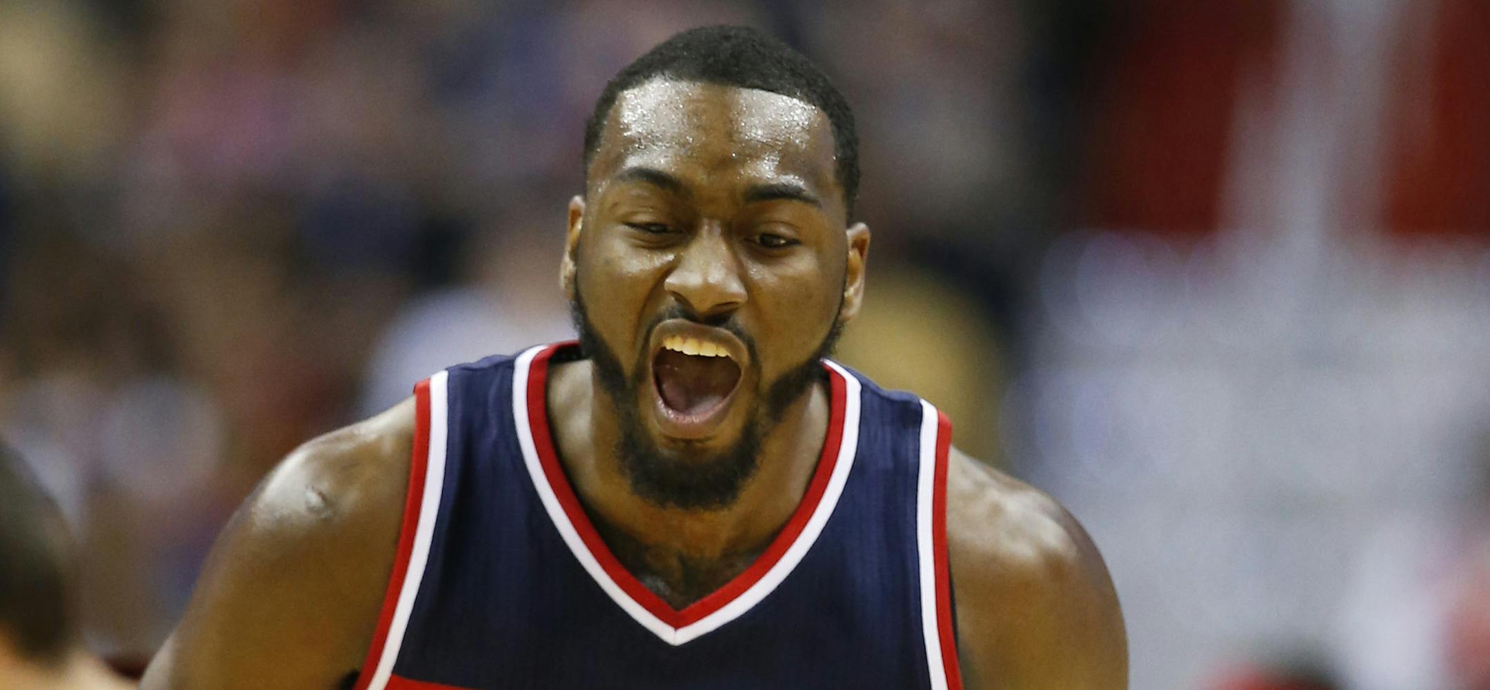 Washington Wizards guard John Wall reacts after a score in the first half of an NBA basketball game against the Cleveland Cavaliers, Friday, Nov. 21, 2014, in Washington. (AP Photo/Alex Brandon)