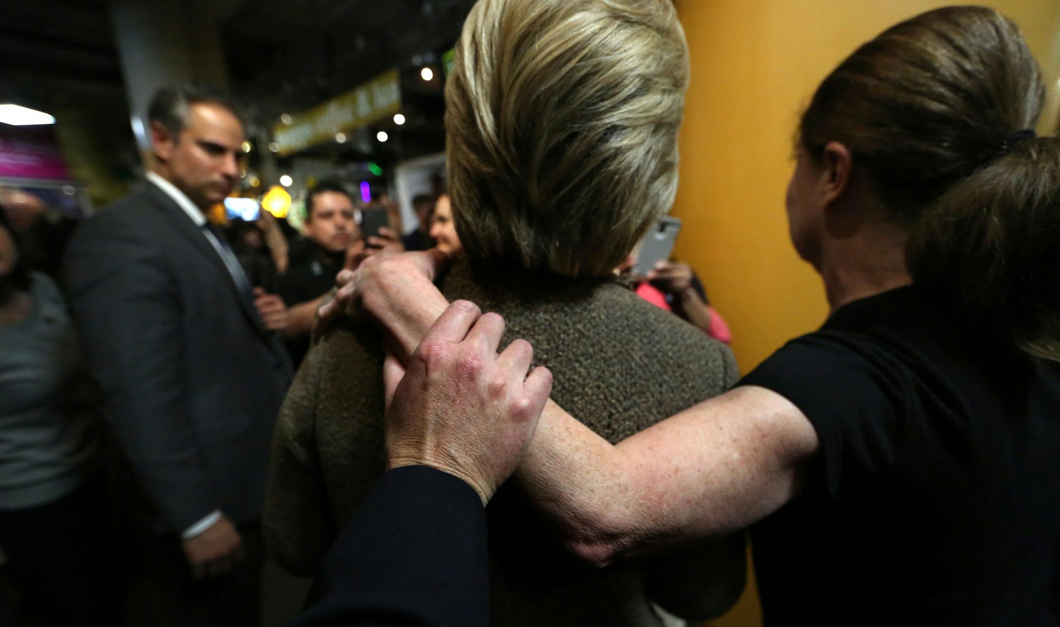 A security agent held secure the arm of a supporter during the taking of a picture while protecting Democratic presidential candidate Hillary Clinton while she was making a campaign stop at the Midtown Global Market in Minneapolis on Super Tuesday.