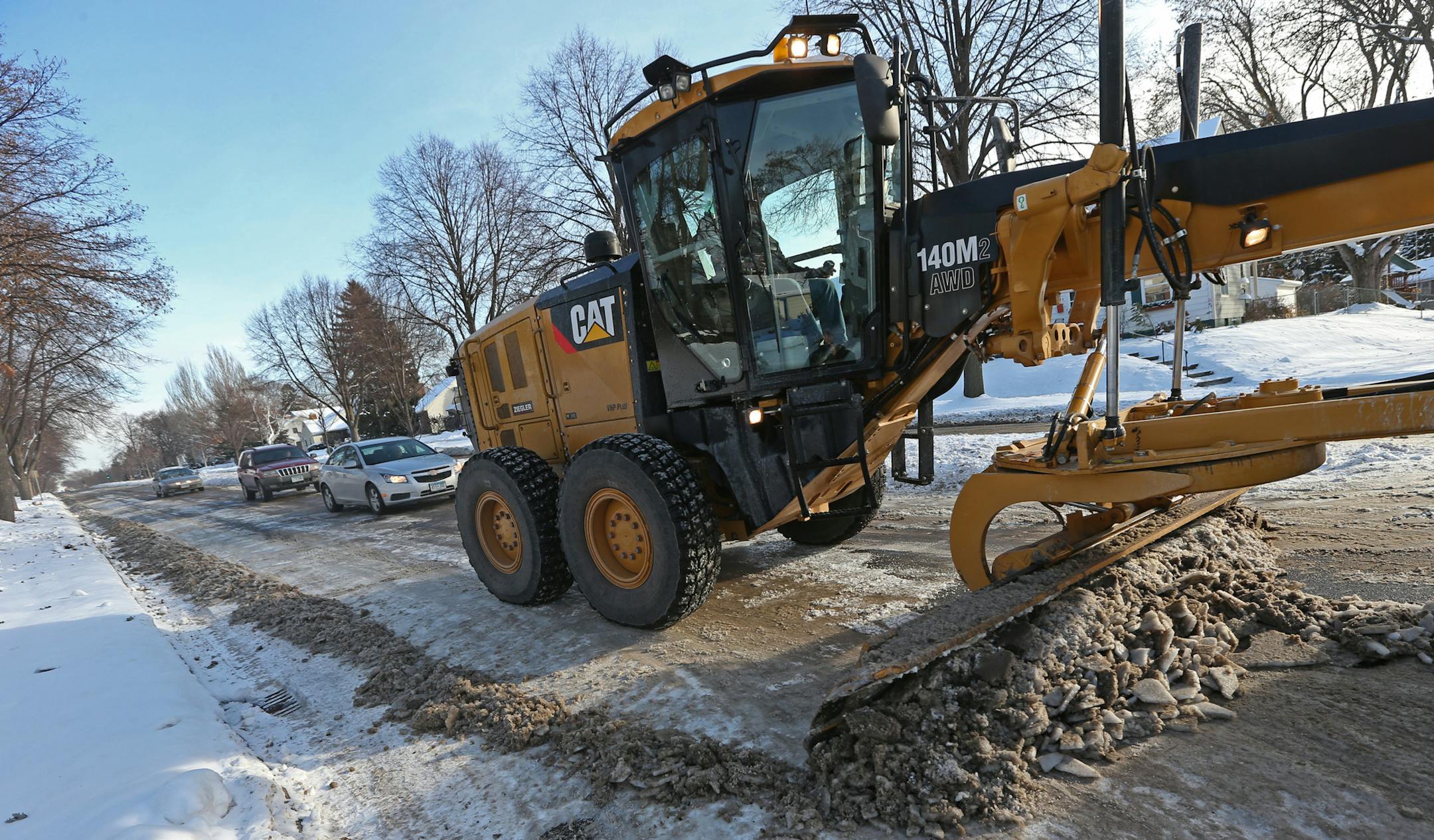 St. Paul city crews used graders to clear the compacted ice and snow off of Montreal Ave near the intersection of Howell St, on 12/12/13. Bruce Bisping/Star Tribune bbisping@startribune.com