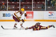 Minnesota forward Abigail Boreen (22) has the puck poked away by Minnesota Duluth defenseman Maggie Flaherty (29) in the first period.