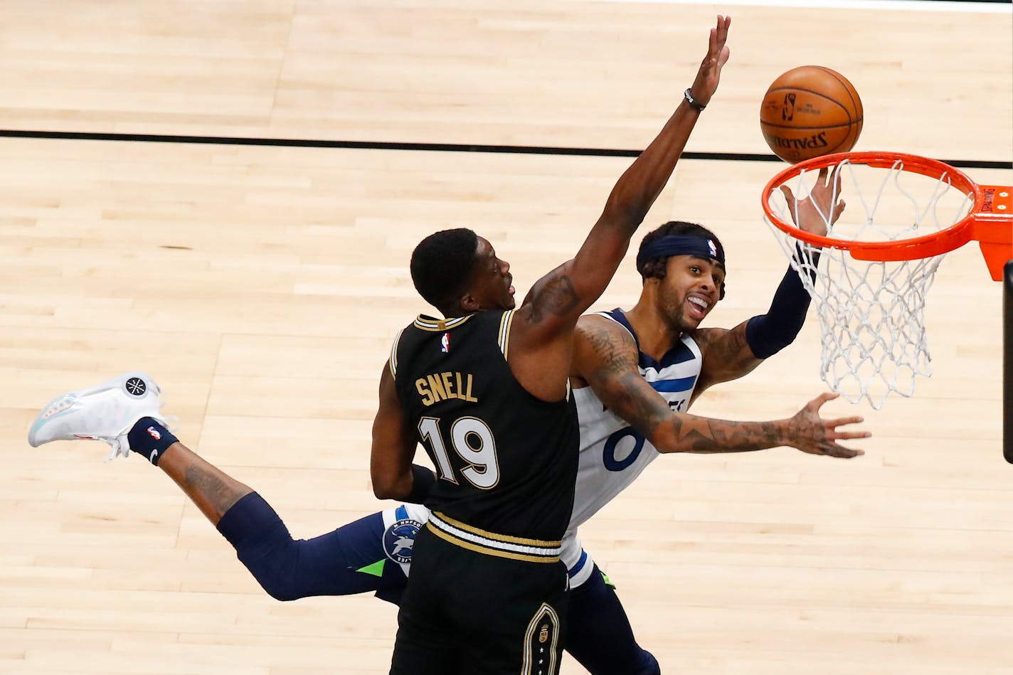 Minnesota Timberwolves guard D'Angelo Russell (0) is fouled by Atlanta Hawks guard Tony Snell (19) in the first half of an NBA basketball game on Monday, Jan. 18, 2021, in Atlanta. (AP Photo/Todd Kirkland)