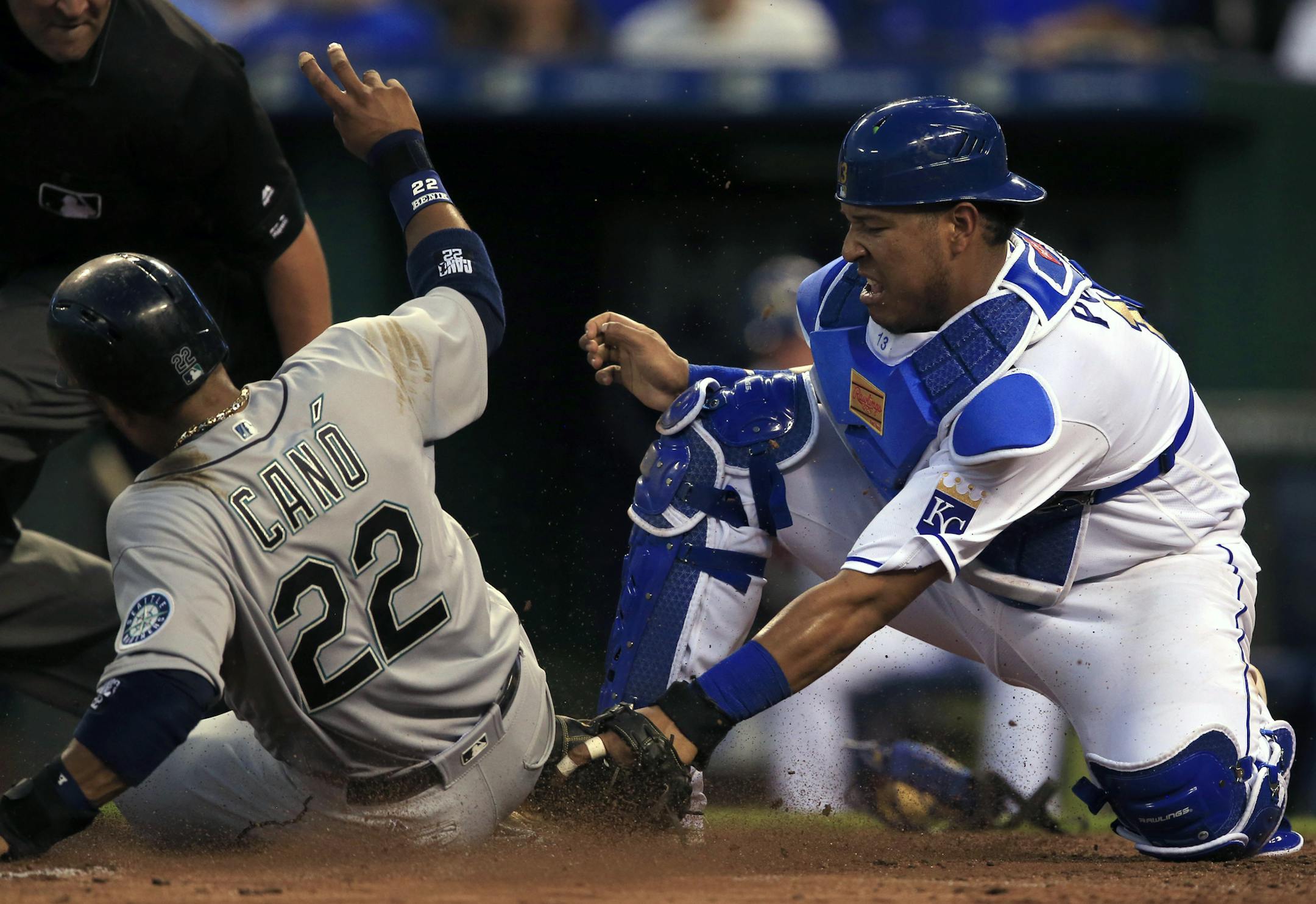 Seattle Mariners' Robinson Cano (22) scores on an error by Kansas City Royals catcher Salvador Perez, right, during the sixth inning of a baseball game at Kauffman Stadium in Kansas City, Mo., Friday, July 8, 2016. (AP Photo/Orlin Wagner)