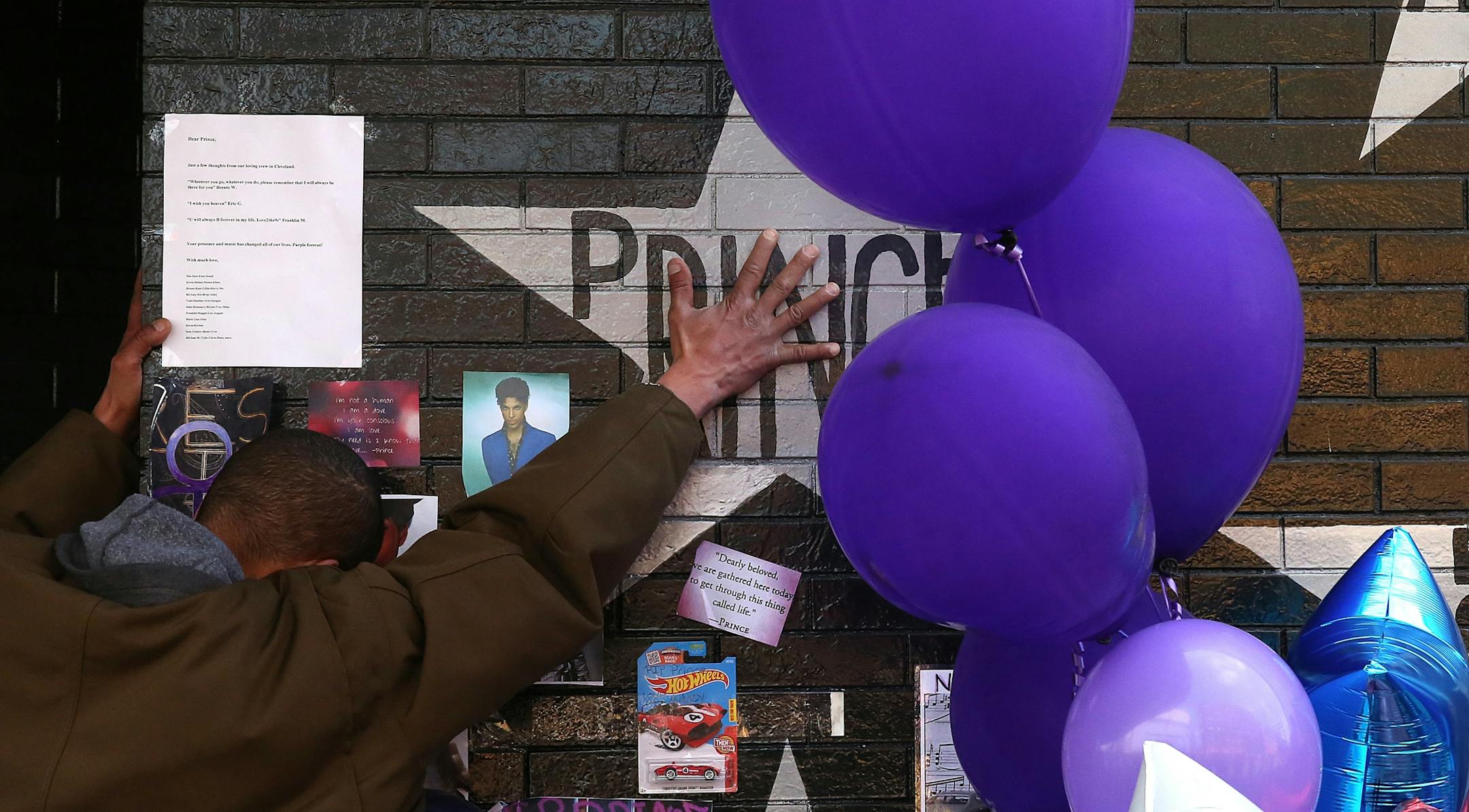 A mourner and fan touched the star for Prince on a wall at First Avenue. Hundreds of fans continued to lay flowers, mementos and take photographs at the site.