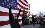 FILE - Members of the Proud Boys cheer on stage as they and other right-wing demonstrators rally, Saturday, Sept. 26, 2020, in Portland, Ore. Presiden