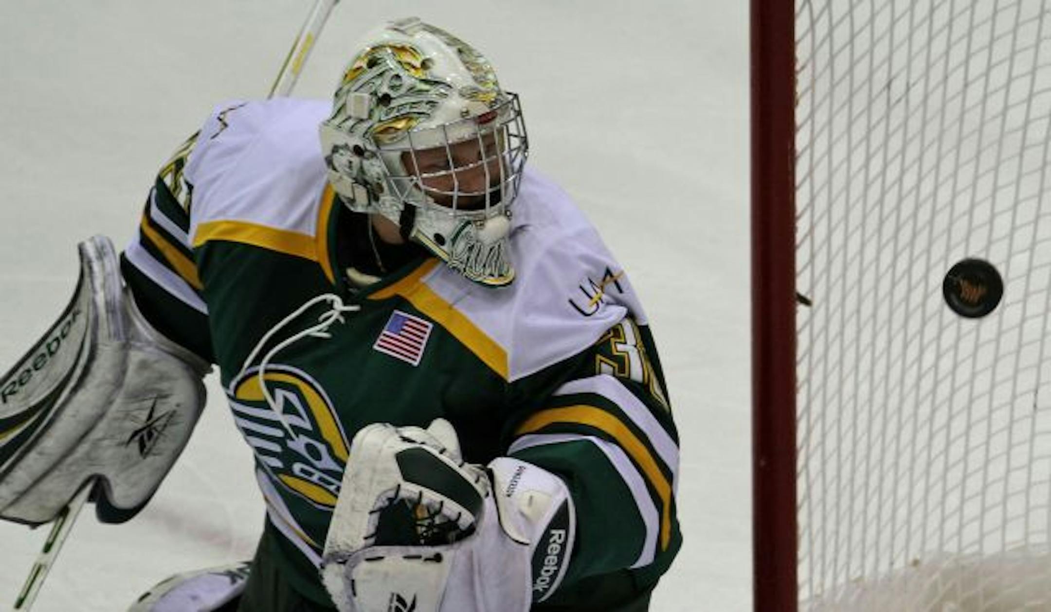 Gopher Hockey vs. Alaska Anchorage. (left to right) Alaska goalie Rob Gunderson couldn't stop Minnesota's Nate Condon's shot from going in for the first Gopher goal, first period action.