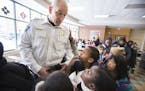 Inspector Mike Friestleben of the Minneapolis Police Department's Fourth Precinct lines up with third graders during lunch at Lucy Craft Laney Communi