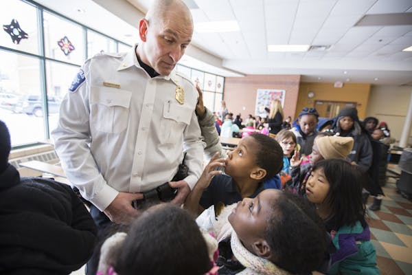 Inspector Mike Friestleben of the Minneapolis Police Department's Fourth Precinct lines up with third graders during lunch at Lucy Craft Laney Communi