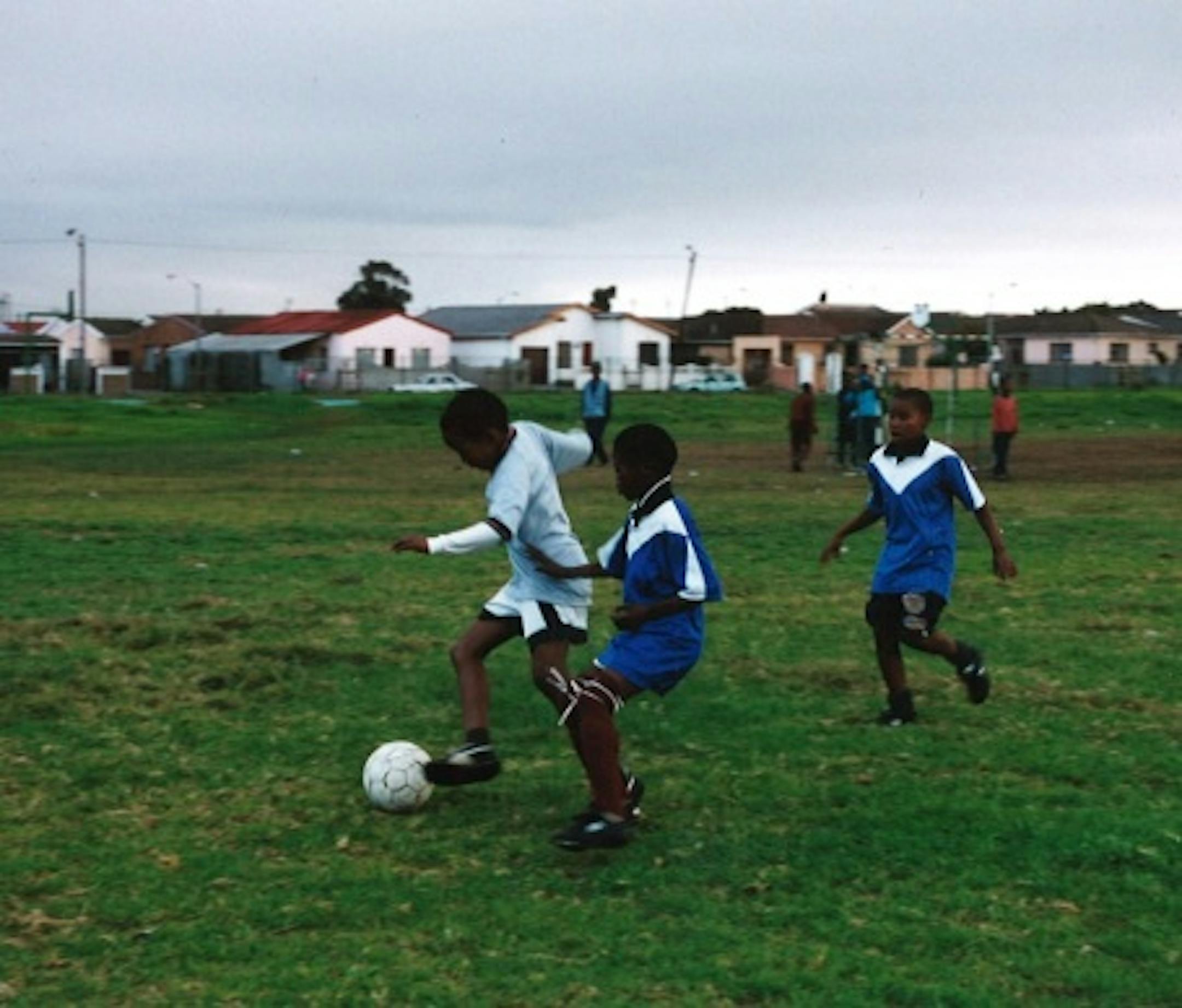 Kids playing soccer in South Africa in shoes donated by Minnesotans.