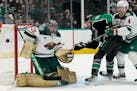 Wild goaltender Marc-Andre Fleury and Jon Merrill defend the goal against Dallas center Tyler Seguin during the first period