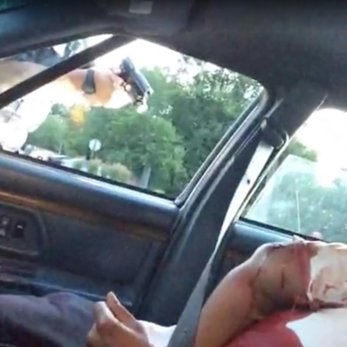 A screengrab from the video posted to Facebook shows the aftermath of the shooting, with a man bleeding in the seat and a police officer pointing a gun into the car.