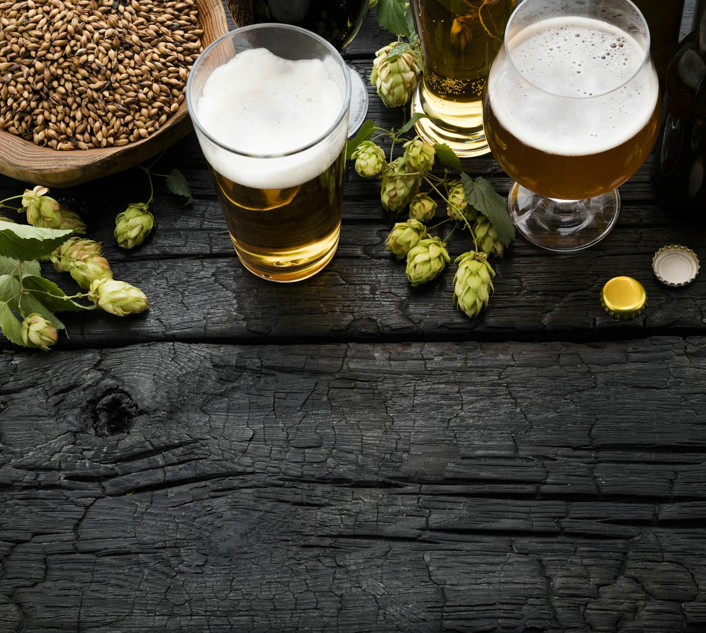 Beer and ingredients on black wooden table. Top View