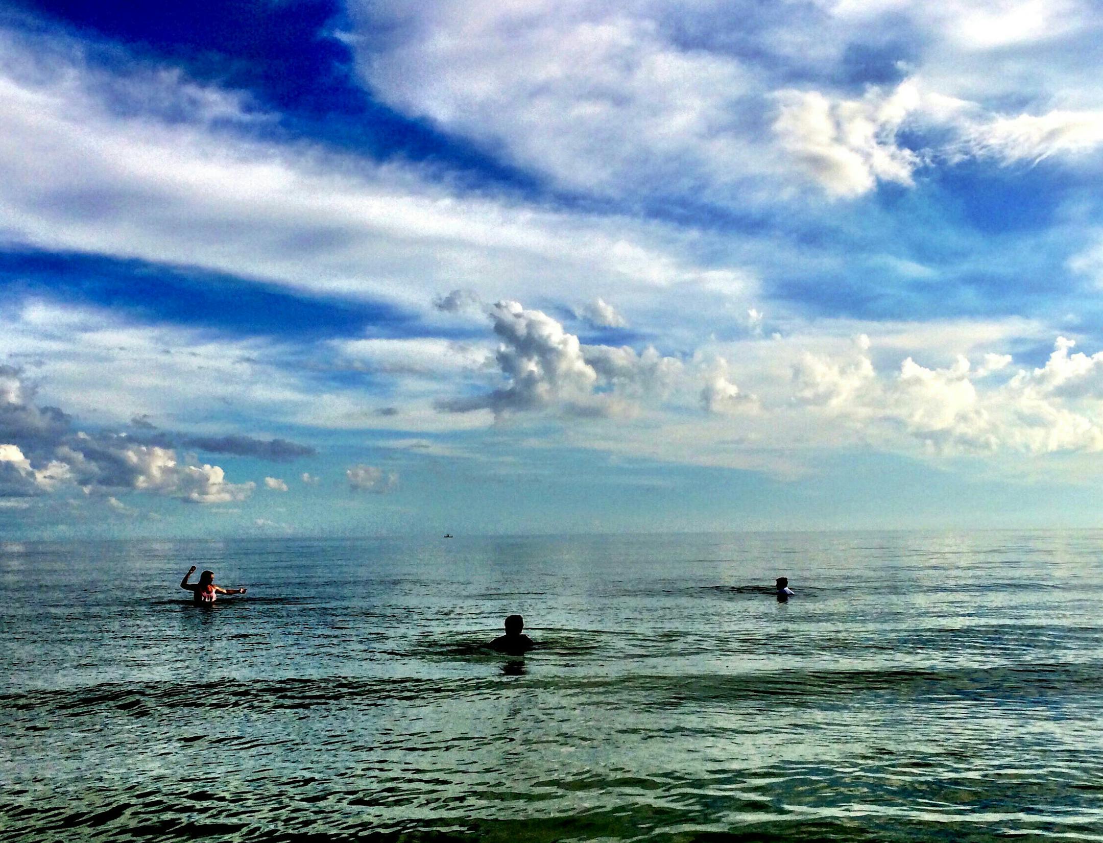 Autumn Schwintek and Brayden and Justin Buchta play catch in the waters off Sanibel Island.