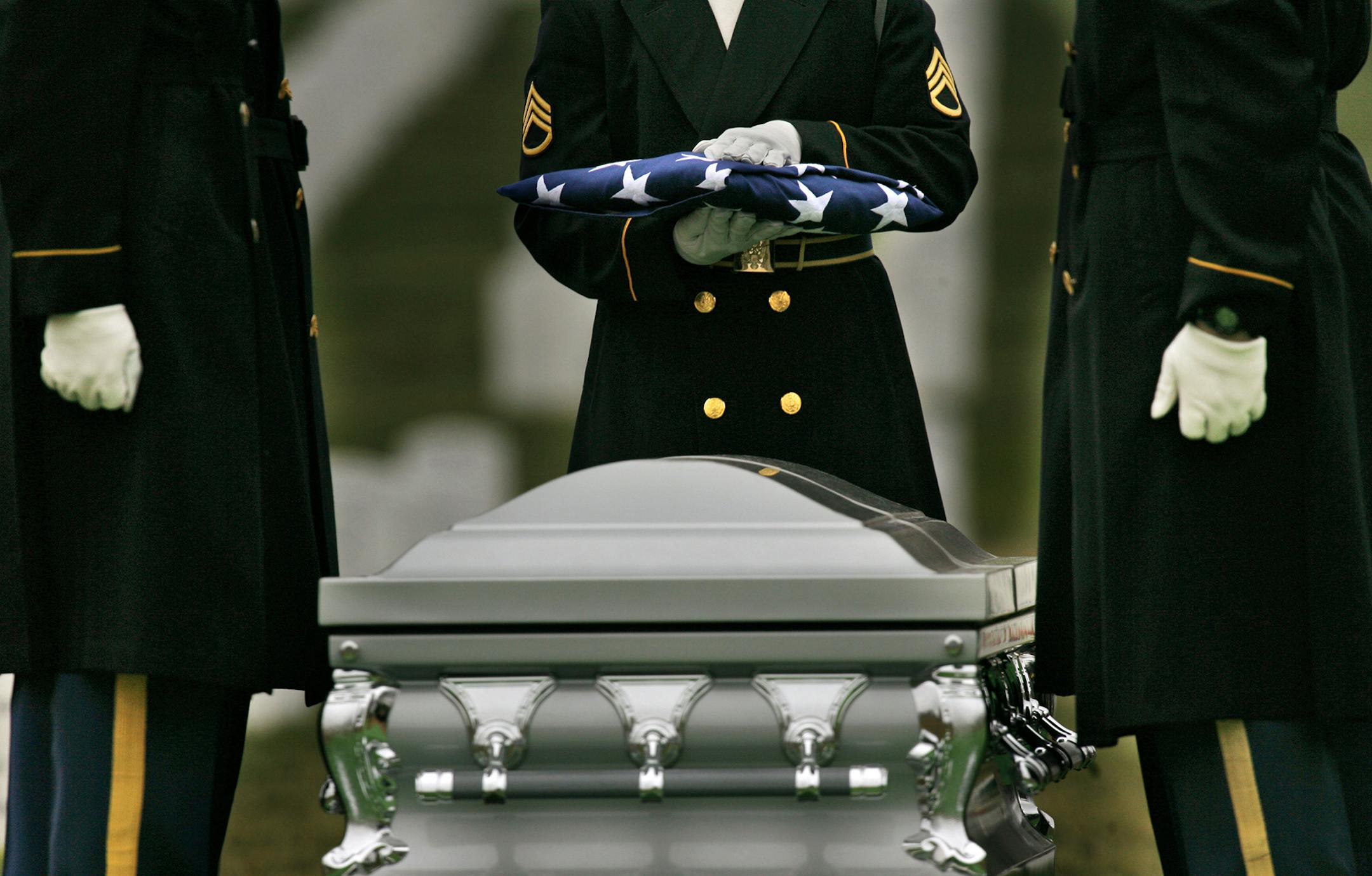 Members of a military honor guard pause after folding the American Flag of Staff Sgt. Jamie D. Wilson, of San Diego, during funeral services at Arlington National Cemetery in Arlington, Va., Friday, Feb. 2, 2007. Wilson died last month in Fallujah of wounds suffered in Karmah. (AP Photo/Jacquelyn Martin) ORG XMIT: MIN2016091217361150