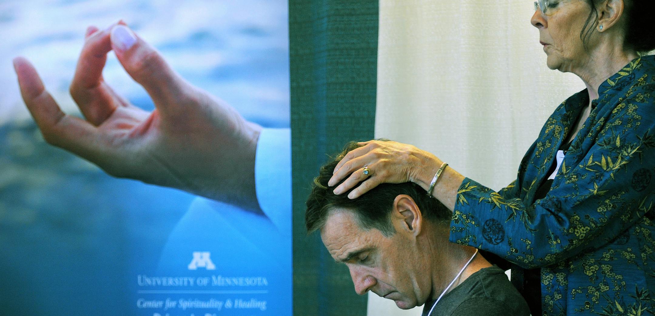UCare held health and wellness fair for people with disabilities at the Earle Brown Heritage Center in Brooklyn Center on Thursday August 9, 2012. Reiki practitioner Kathy Steele laid her hands on Rob Ley of Minneapolis at the U of M Center for Spirituality & Healing both. Reiki is a energy healing practice and Rob Ley said he felt "energized " after the 10 minute session. ] Richard.Sennott@startribune.com Richard Sennott /Star Tribune. , Brooklyn Center Minn, Minn. Thursday 08/09/12) ** (cq)