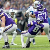 Minnesota Vikings quarterback Kirk Cousins (8) is tripped up by Ed Ingram (67) in the first quarter.