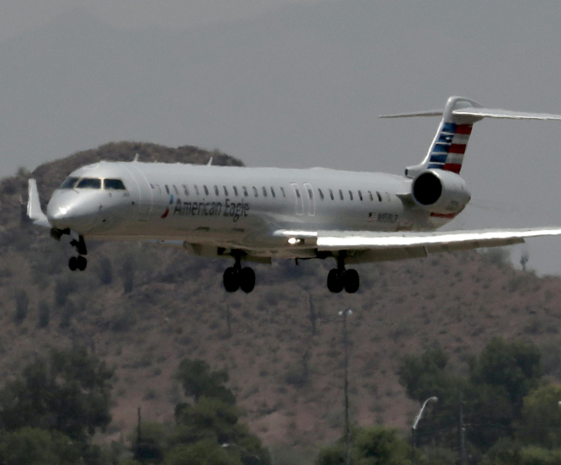 An American Eagle jet is seen through heat ripples as it lands at Sky Harbor International Airport, Monday, June 19, 2017 ,in Phoenix. American Airlines cancelled dozens flights out of Phoenix today due to extreme heat. The cancellations are for operations by smaller regional jets that have lower maximum operating temperatures than full size jets. The smaller jets can't operate when it's 118 degrees or higher. (AP Photo/Matt York)