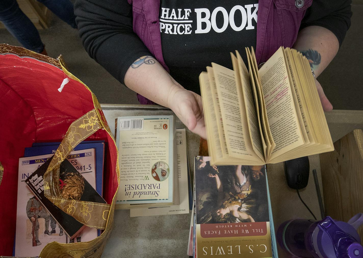 Half-Price Books store manager Jenna Warner went through a bag of book that were dropped off for sale. ] CARLOS GONZALEZ &#x2022; cgonzalez@startribune.com &#x2013; January 27, 2018, St. Louis Park, MN, Half-Price Books, Marie Kondo has people loving or hating her plan to declutter our homes and our lives? How influential is she? Some Twin Cities charities, consignment shops and bookstores say her methods have filled their shelves.