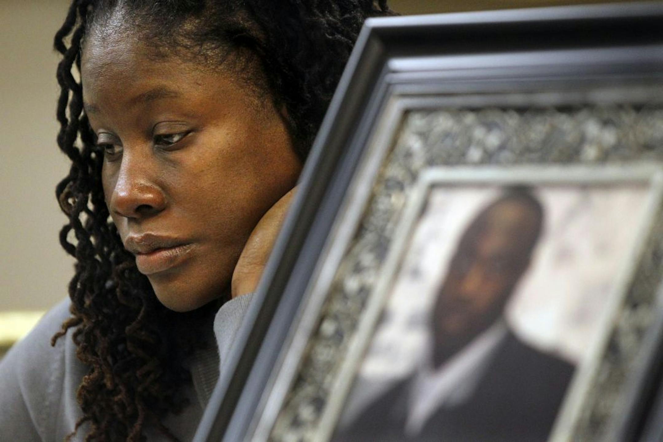 Shalema Blue, near a photo of her brother Quincy Blue, hopes someone will provide information about his death. His charred body was found in a St. Paul alley.