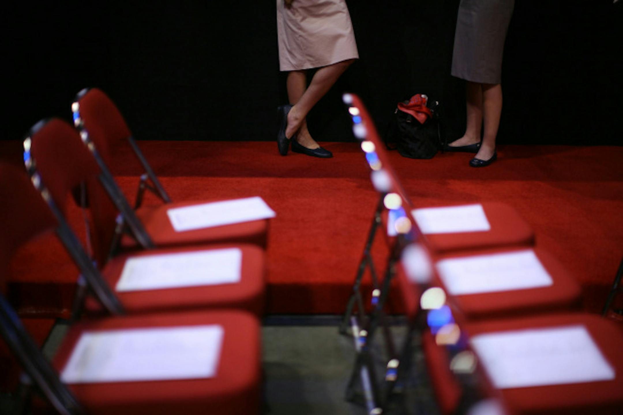 Two volunteers visited at the side of the floor after distributing materials to the delegates' chairs Wednesday afternoon.