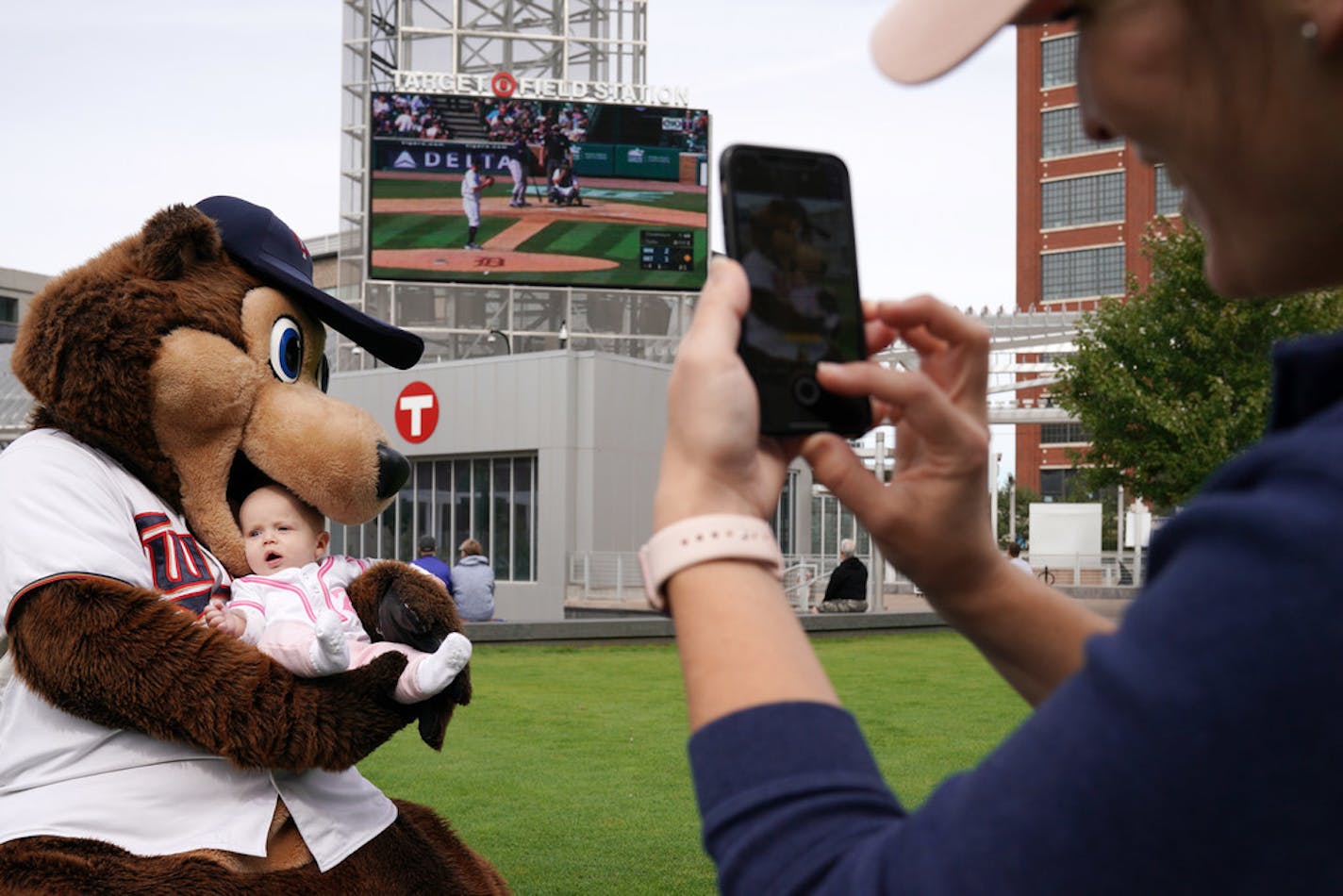 Chrissie Olson took a photo of her 5-month-old daughter Marion as T.C. Bear jokingly took a bite of the youngster during a free "Postseason Push" party to watch the Twins play the Tigers in Detroit last Thursday.