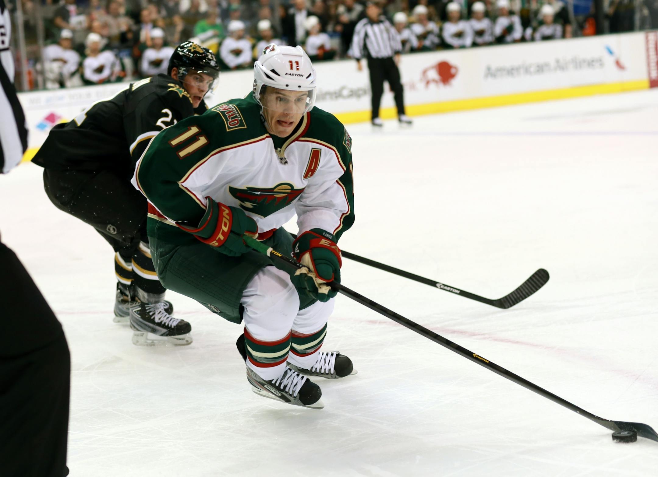 Minnesota Wild left wing Zach Parise (11) makes his move down the boards as Dallas Stars left wing Loui Eriksson (21) defends during the second period of an NHL hockey game Monday, March 25, 2013 in Dallas.