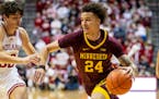 Minnesota guard Sean Sutherlin (24) makes a move toward the basket while Indiana guard Trey Galloway (32) defends during the first half of an NCAA col