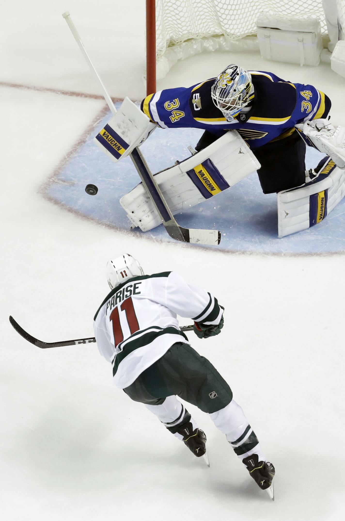 St. Louis Blues goalie Jake Allen, top, deflects a shot from Minnesota Wild's Zach Parise (11) during the second period of an NHL hockey game Thursday, Oct. 13, 2016, in St. Louis. (AP Photo/Jeff Roberson)