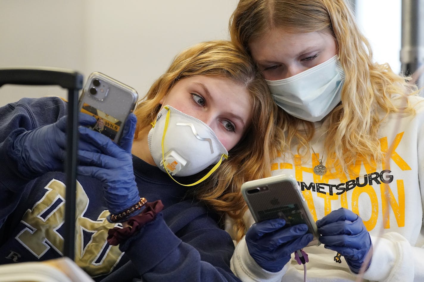 Rachel Miner, 15, left, of Emmetsburg, Iowa sat with Carlotta Haas, 15, right, a German foreign exchange student from Duesseldorf who had been living with her but was called home as they waited for her flight Wednesday at MSP.