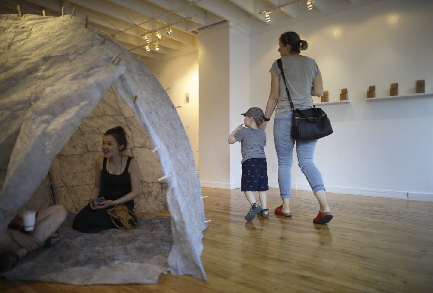 Finnish artist Mari Mathlin sat in a tent-like piece she was exhibiting during the opening for a show of her work at Hair and Nails in Minneapolis.