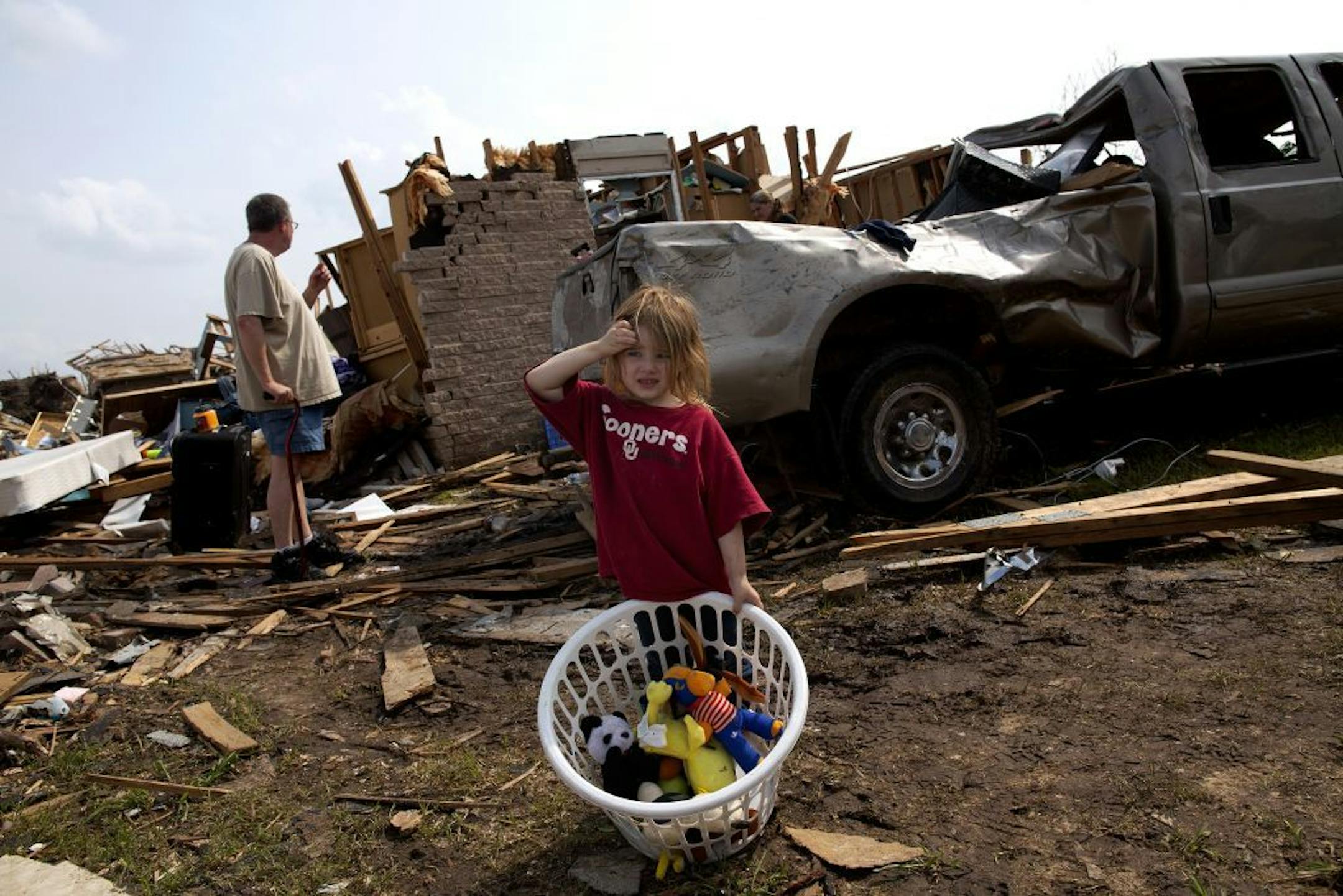 A child stands in front of a house and vehicle that were destroyed by a massive tornado in Moore, Okla., May 24, 2013. During times of national tragedy, Twitter and Facebook become sounding boards for the grieving masses.